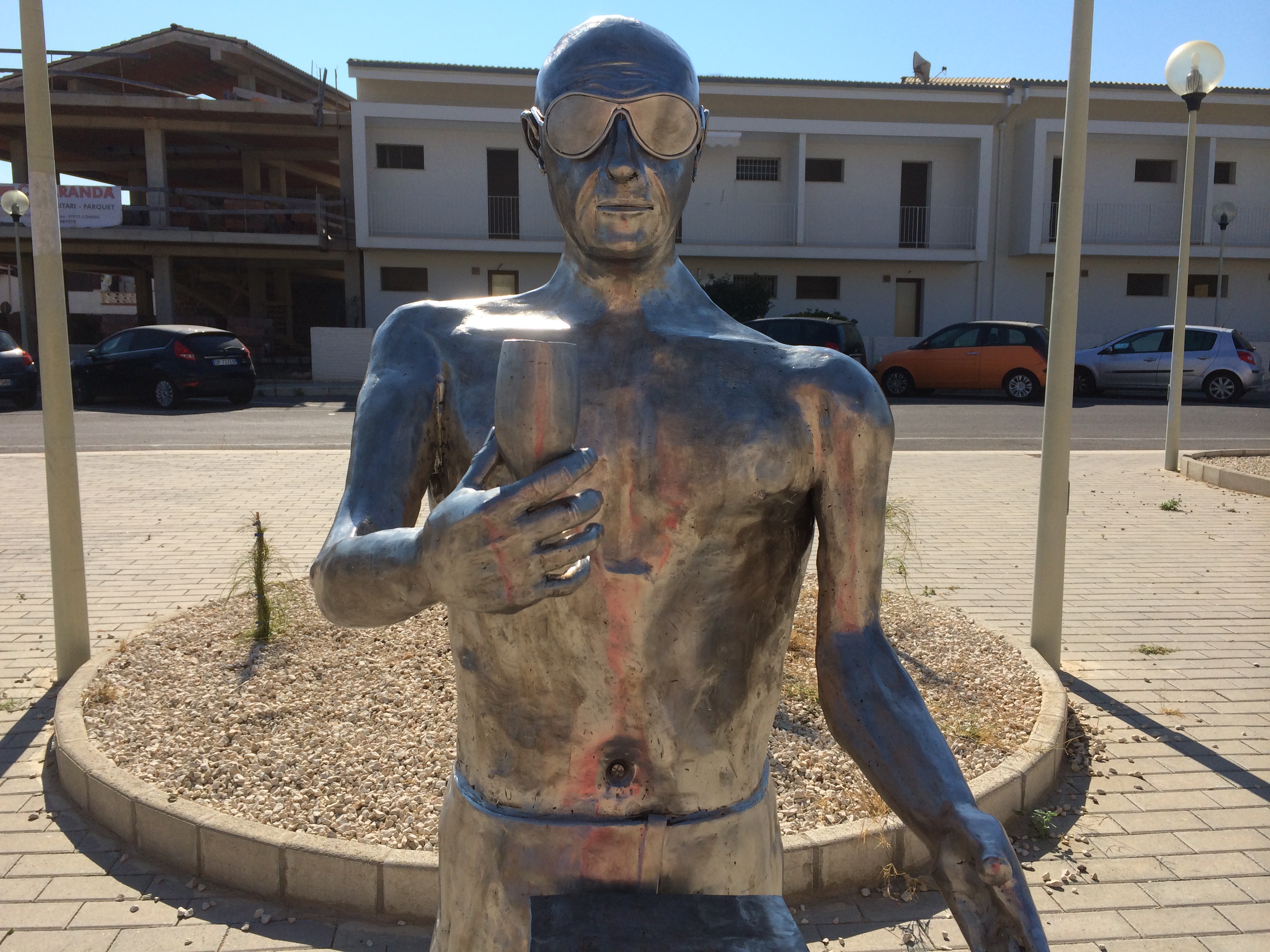  Statua in ferro di Montalbano all’entrata di P.Secca: ha occhiali da sole e calice di spumante